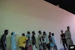 Security officers line up Sudanese people detained at a police station in Rosetta, Egypt, after rescued from a boat capsized off the Mediterranean coast near the Egyptian city of Alexandria, Sept. 21, 2016.