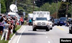 An ambulance carrying American missionary Nancy Writebol, 59, who is infected with Ebola in West Africa arrives past crowds of people taking pictures at Emory University Hospital in Atlanta, Georgia, Aug. 5, 2014.