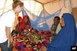 Doctors Without Borders Emergency Coordinator Aria Danika consults with parents of a malnourished child at the Hilaweyn refugee camp, Dollo Ado, Ethiopia, October 26, 2011.