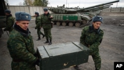 FILE - Russia-backed rebels unload 120mm mortars from trucks near Luhansk, eastern Ukraine, Oct. 15, 2015.