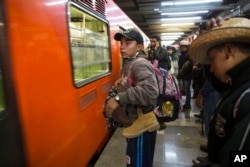 Central American migrants stand waiting for a subway car after leaving the temporary shelter in the Jesus Martinez stadium, in Mexico City, Nov. 9, 2018.