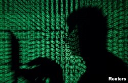 A man holds a laptop computer as code is projected on him in this illustration made on May 13, 2017. Capitalizing on spying tools believed to have been developed by the U.S. National Security Agency, hackers staged a cyberassault with a self-spreading malware that has infected tens of thousands of computers in dozens of countries.