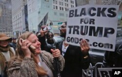 Pedestrians cheer as pro-Trump supporters, gather to voice their support for Trump's election as president, Nov. 9, 2016, outside Trump Tower in New York.