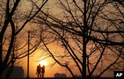 A couple walks along the Taedong River bank in Pyongyang, North Korea, during sunset, Jan. 6, 2017.