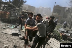FILE - Men transport a casualty after what activists said were airstrikes by forces loyal to Syria's President Bashar al-Assad on a busy marketplace in Douma, near Damascus, Syria, Aug. 12, 2015.
