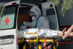 Medicinski radnici transportuju osobu oboljelu od Covida, Rusija, juni 2021.
