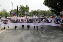 印度示威者在新德里手举写着“我们的国家我们的土地，中国军队滚出去”字样的横幅举行抗议活动。（2020年6月19日）