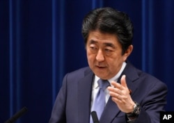 FILE - Japan's Prime Minister Shinzo Abe answers a question from a journalist during a press conference at the prime minister's official residence in Tokyo, July 20, 2018.
