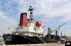 FILE - In this March 4, 2016 file photo, crewmen of the North Korean cargo vessel Jin Teng stand on the middle of the deck as it unloads its cargo while docked at Subic Bay, in Zambales province, northwest of Manila, Philippines.