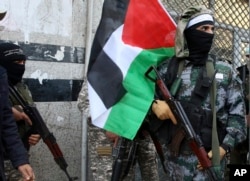 Masked militants from Al Aqsa Martyrs' Brigade, a militia linked to the Fatah movement, hold their rifles and the Palestinian flag during a protest to condemn the decision by President Trump to recognize Jerusalem as Israel's capital, in Gaza City, Dec. 7, 2017.