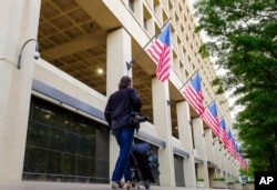 FILE - A member of the news media walks in front of the FBI headquarters building early in the morning in Washington, May 10, 2017.