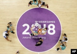 India's Rajapriyadharshini Rajaganapathi, right, jumps against Kazakhstan's Nadezhda Kondrakova during their women's basketball match at the 18th Asian Games in Jakarta, Indonesia, Aug. 17, 2018.