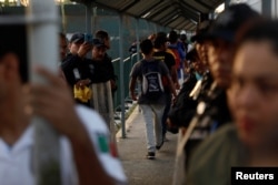 Central American migrants, part of a caravan trying to reach the U.S., enter the Mexican border and customs facility in Ciudad Hidalgo, Mexico, Oct. 23, 2018.
