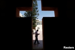 FILE - An Iraqi Christian man from Mosul, who fled with his family from violence in their country, reads a book at the Latin Patriarchate Church in Amman, Jordan, Aug. 21, 2014.