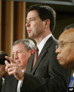 Jim Comey, U.S. Attorney for New York, center, flanked by Attorney General John Ashcroft, left, and Deputy Attorney General Larry Thompson gestures during a news conference at the Justice Department in Washington Thursday, Aug. 1, 2002.