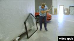 Максим Гербут pасновник, генеральний директор РassivDom б'є молотком по вікну.