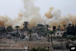 Smoke rises from explosions demolishing houses on the Egyptian side of the border town of Rafah as seen from the Palestinian side of Rafah in the southern Gaza Strip, Nov. 4, 2014.