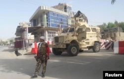 FILE - An Afghan security force personnel stands guard at the entrance gate of the government compound of Farah province, western Afghanistan, May 15, 2018.