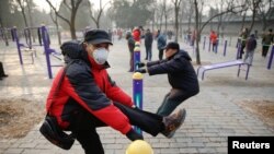 A man wearing a face mask exercises in a park despite a red alert issued for air pollution in Beijing, China, Dec. 18, 2016.