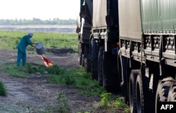 Ukraine -- A nurse empties a bucket of blood outside a field hospital in Zaporizhya following the surgery of a Ukrainian serviceman who was wounded during a military operation on July 31, 2014.