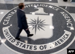 FILE - A man crosses the Central Intelligence Agency (CIA) logo in the lobby of CIA Headquarters in Langley, Virginia.