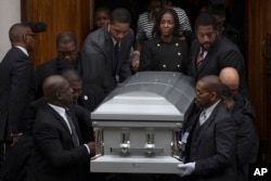 在纽约市的布鲁克林，在被射杀的黑人青年阿凯·格利的葬礼中，他的女友（中右）走出教堂（2014年12月6日）