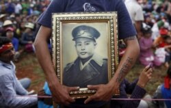 Seorang pria memegang potret Jenderal Aung San, ayah dari pemimpin pro-demokrasi Myanmar Aung San Suu Kyi, selama pidatonya tentang pendidikan pemilih di kotapraja Hsiseng di negara bagian Shan, Myanmar, 5 September 2015. (Foto: REUTERS/Soe Zeya Tun )