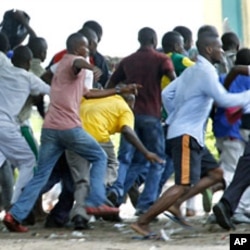 Supporters of Congolese opposition leader Etienne Tshisekedi run as riot police charge with tear gas and live fire outside their candidate's headquarters in Kinshasa, Democratic Republic of Congo, December 8, 2011