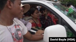 Kem Ley's wife Pou Rachana weeps as her late husband's body is driven through Phnom Penh on the way to his funeral at Wat Chak pagoda, Cambodia, July 10, 2016.