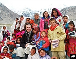 Greg Mortenson poses with schoolchildren in Afghanistan.
