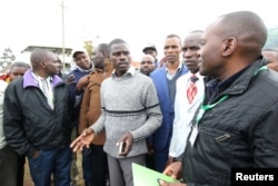 Igembe South parliamentary candidate on an Independent ticket John Paul Mwirigi, center, talks to his agents at their constituency tallying center in Maua Girls High School, in Maua, Kenya, Aug. 9, 2017.
