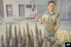 Lam Tak-fai, acting head of Ports and Maritime Command in Hong Kong holds a rhino horn smuggled into the country on a ship from Cape Town, South Africa, in November 2011