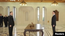 Riyad Hijab is sworn in as new Prime Minister by Syrian President Bashar al-Assad (R) in Damascus in this handout photo distributed by Syrian News Agency, June 26, 2012