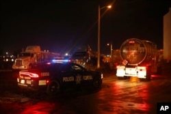 Federal police escort loaded fuel tankers carrying gasoline to parts of the country suffering shortages as they leave a Petroleos Mexicanos, or Pemex, fuel depot and distribution center in the port city of Veracruz, Mexico, Jan. 9, 2019.