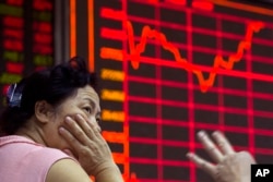 A Chinese investor monitors stock prices at a brokerage in Beijing on Aug. 26, 2015.