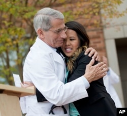 FILE - Dr. Anthony Fauci, head of NIH's National Institute of Allergy and Infectious Diseases, hugs Nina Pham as she's discharged from treatment in Bethesda, Maryland, Oct. 24, 2014.