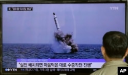 FILE - A South Korean man watches a TV news program showing an image published in North Korea's Rodong Sinmun newspaper of North Korea's ballistic missile believed to have been launched from underwater, at Seoul Railway station in Seoul, South Korea, May 9, 2016.