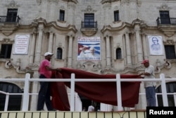 Workers make final touches to one of the podiums near Havana's cathedral, that will be used during the visit of Pope Francis to Cuba, Sept. 17, 2015.