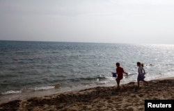 FILE - Children play at a beach in Hammamet, Tunisia, Feb. 19, 2013.