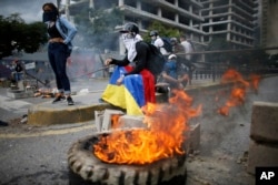 FILE - Masked anti-government demonstrators protest against the installation of a constitutional assembly in Caracas, Venezuela, Aug. 4, 2017.