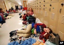 Emily Hindle lies on the floor at an evacuation shelter set up at Rutherford High School, in advance of Hurricane Michael, which made landfall, in Panama City Beach, Fla., Oct. 10, 2018.