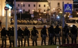 FILE - Belarusian law enforcement officers stand guard during a rally of opposition supporters following the presidential election in Minsk, Belarus, Aug. 10, 2020.