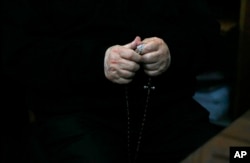 FILE - Rev. Fernando Karadima, Chile’s most infamous pedophile priest, holds a rosary in court before testifying in a case that three of his victims brought against the country’s Catholic Church in Santiago, Chile, Nov. 11, 2015.