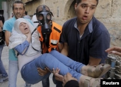 A Palestinian woman affected by tear gas is evacuated by medics during clashes between Palestinians and Israeli police on the compound known to Muslims as Noble Sanctuary and to Jews as Temple Mount in Jerusalem's Old City, Sept. 15, 2015.