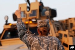 FILE - Konvoi Tentara Angkatan Darat AS mengacungkan ibu jari mereka untuk rekan mereka saat melewati perbatasan Kuwair saat penarikan pasukan dari Irak.