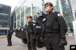 Police officers stand guard in front of the venue of Fourth High-Level Forum on Aid Effectiveness in Busan.