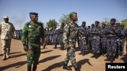 Ivory Coast army chief-of-staff Soumaila Bakayoko (L) and Malian army chief-of-staff Ibrahima Dahirou Dembele (C) inspect Malian troops at an air base in Bamako, Mali, January 16, 2013.