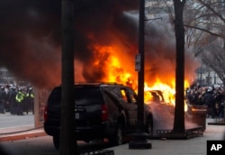 FILE - Demonstrators torch a car during the demonstration in downtown Washington, Jan. 20, 2017, during the inauguration of President Donald Trump.