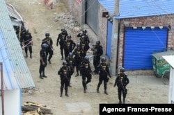 FILE - Members of the Rapid Action Battalion stand guard at the scene of an operation to storm an alleged militants hideout in Dhaka, Bangladesh, April 29, 2019.