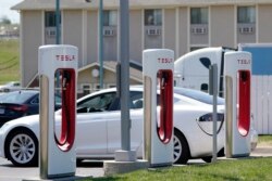 FILE - A Tesla electric vehicle charges at a station in Topeka, Kansas, April 5, 2021.